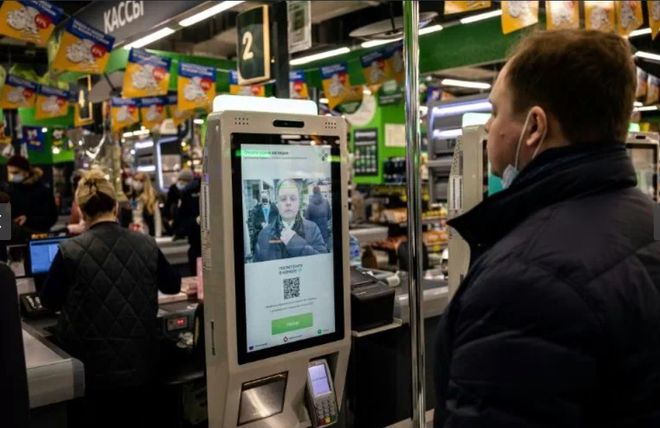 Một khách hàng dùng hệ thống thanh toán nhận dạng khuôn mặt tại quầy tự thanh toán trong một siêu thị ở Moscow, Nga, ẢNH: AFP