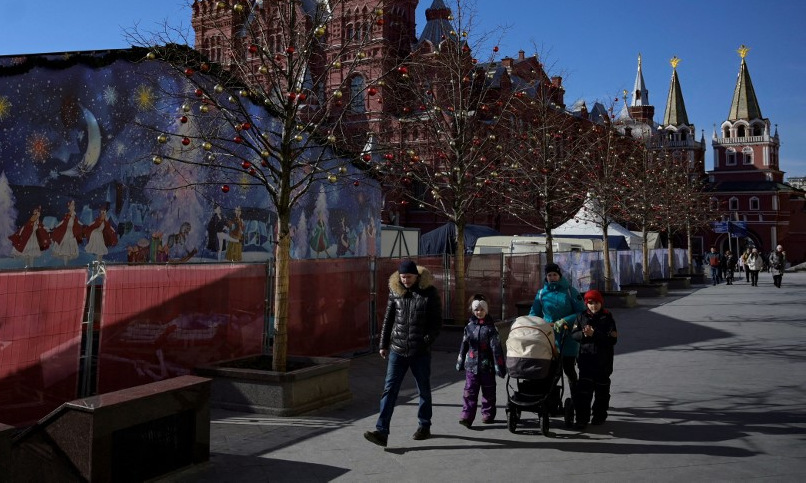 Một gia đình đi bộ tại Quảng trường Đỏ ở thủ đô Moskva của Nga hôm 10/3. Ảnh: AFP.