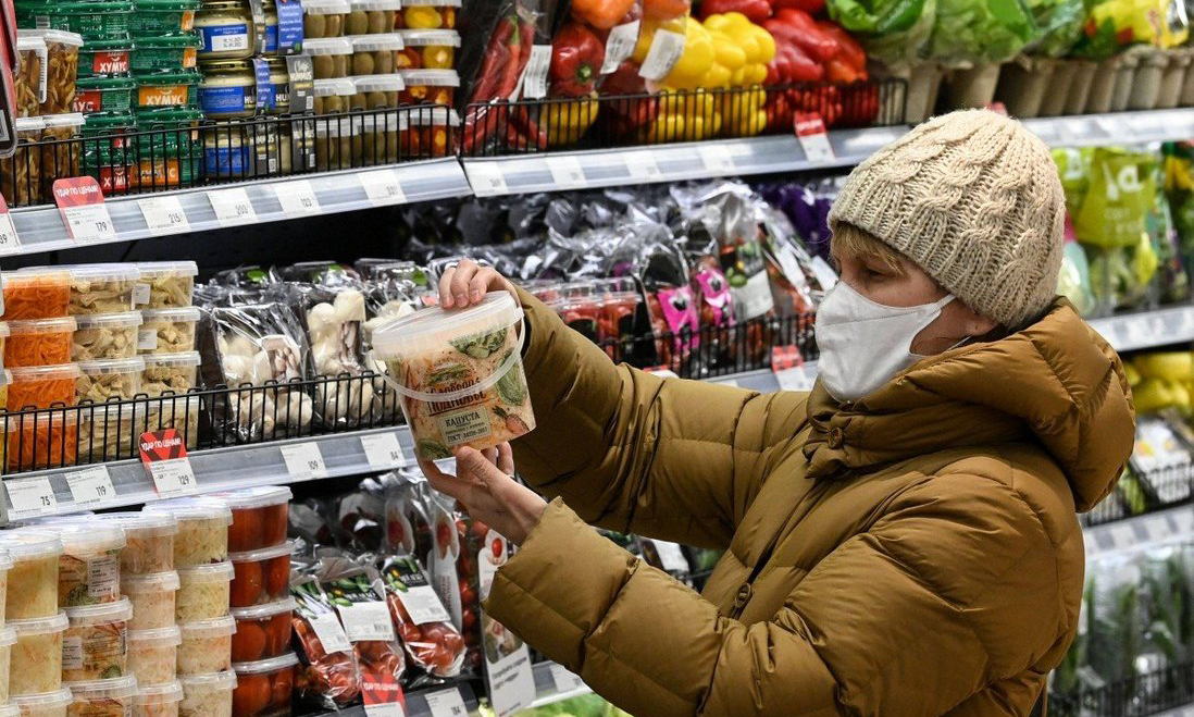 Một người mua hàng đang xem thực phẩm tại siêu thị ở Moskva, Nga hồi tháng 12/2021. Ảnh: AFP.