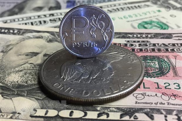 Đồng xu ruble của Nga (phía trên) và đồng USD tại Moskva. (Ảnh: AFP/TTXVN)