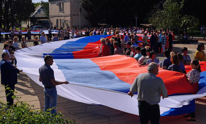 Dân địa phương căng quốc kỳ Nga tại tỉnh Lugansk, miền đông Ukraine, ngày 22/8. Ảnh: RIA Novosti.